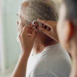 Audiologist adjusting a patient's hearing aid